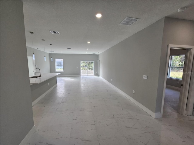 unfurnished living room featuring marble finish floor, visible vents, and baseboards