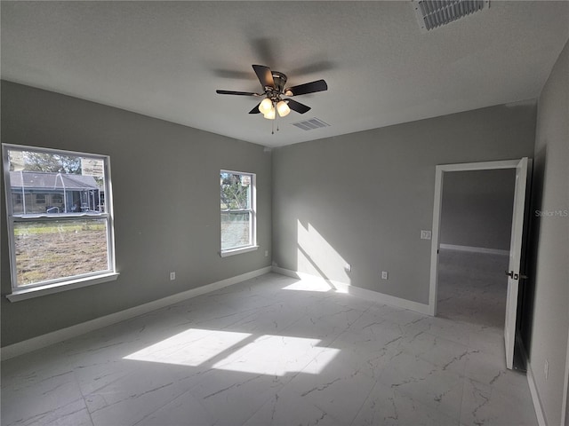 spare room featuring marble finish floor, baseboards, and visible vents