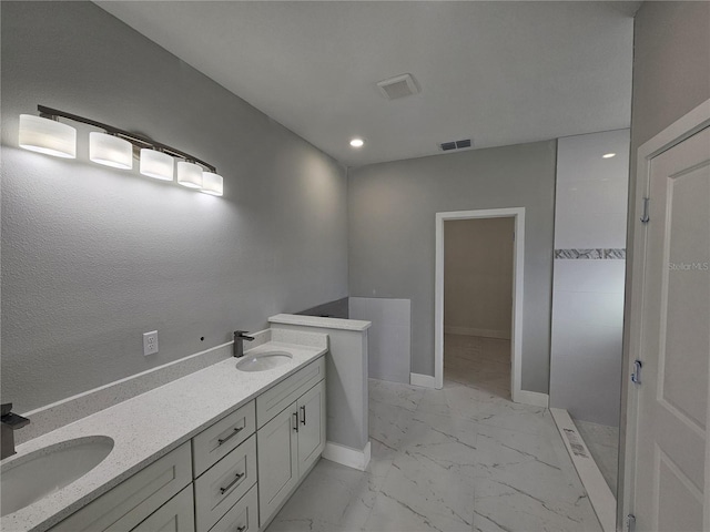 bathroom with marble finish floor, visible vents, a sink, and baseboards