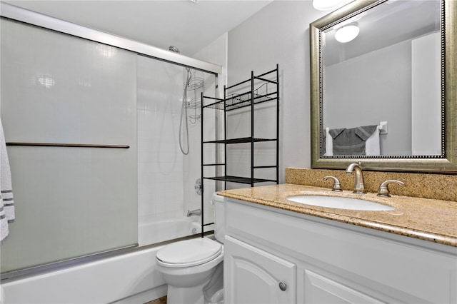 bathroom with toilet, enclosed tub / shower combo, and vanity