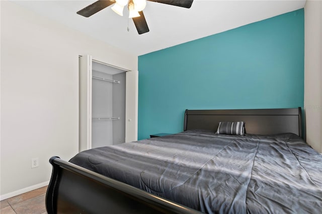 bedroom featuring a ceiling fan, a closet, baseboards, and tile patterned floors