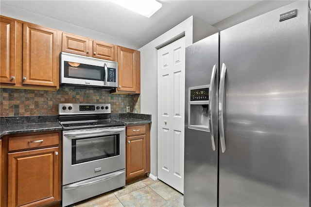 kitchen featuring appliances with stainless steel finishes, backsplash, and brown cabinets