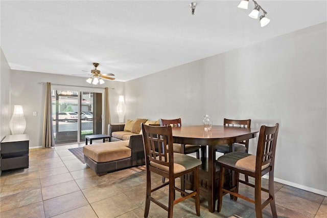 dining space with ceiling fan and baseboards