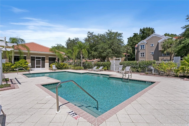 community pool featuring a patio area and fence