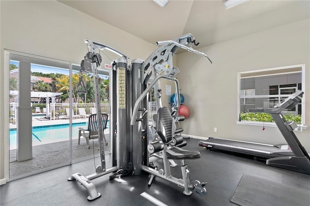 workout area with vaulted ceiling and baseboards