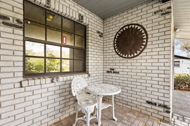 interior space featuring brick floor and brick wall