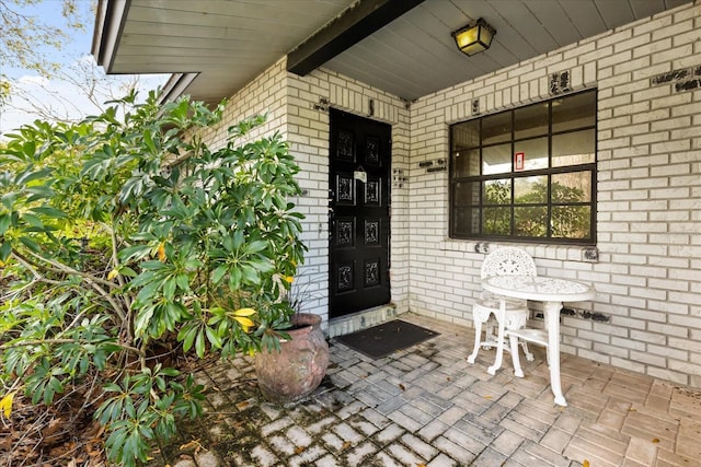 view of exterior entry featuring brick siding