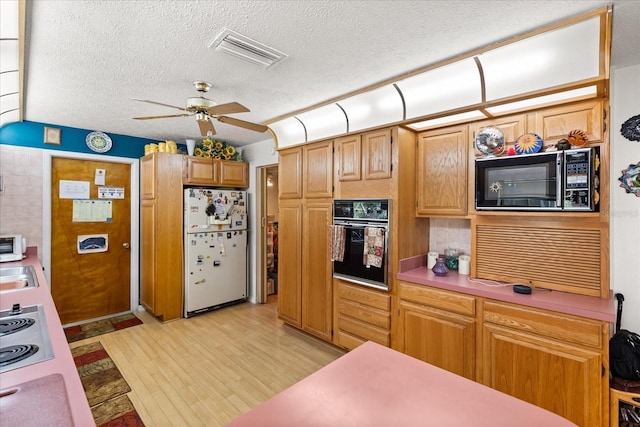 kitchen with visible vents, ceiling fan, light wood-style flooring, light countertops, and black appliances