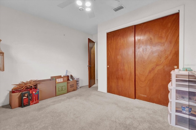 bedroom featuring a ceiling fan, a closet, visible vents, and carpet flooring