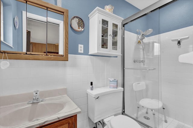 full bathroom featuring a stall shower, tile walls, vanity, and toilet