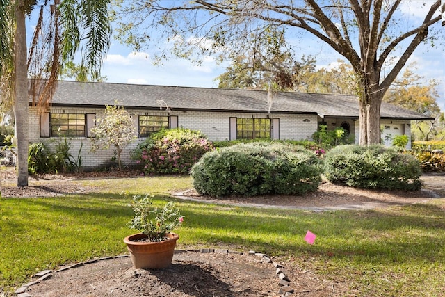 ranch-style house with a garage, a front yard, and brick siding