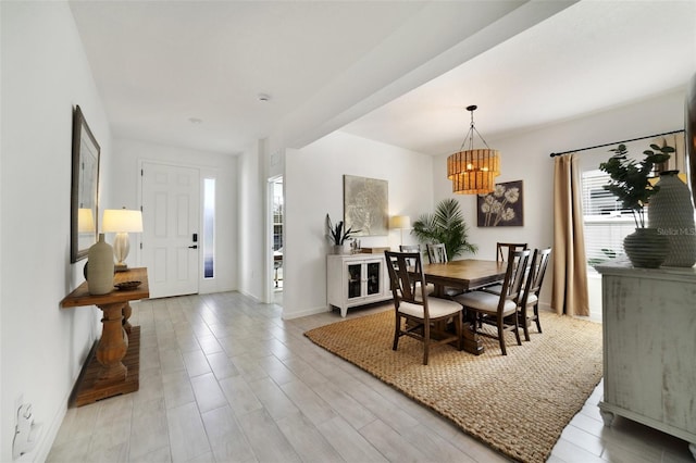 dining space featuring light wood-type flooring and baseboards