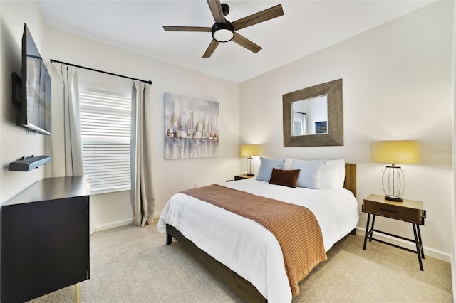 bedroom featuring light colored carpet, ceiling fan, and baseboards