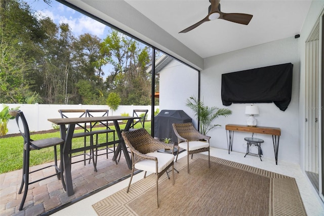 sunroom / solarium featuring a ceiling fan