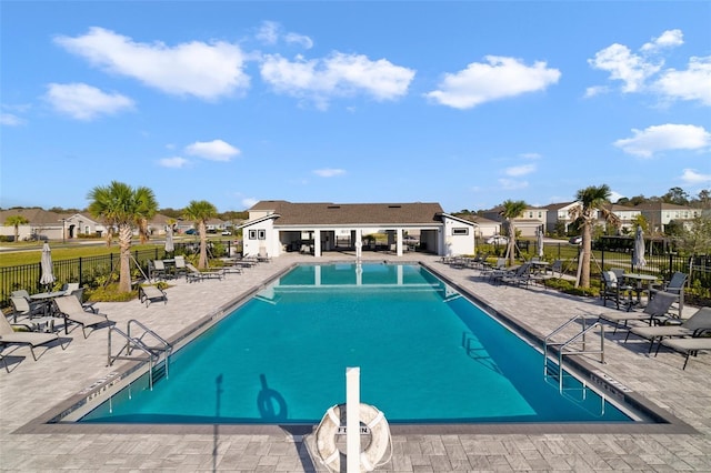 pool with a patio area and fence