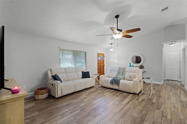 living room with baseboards, visible vents, ceiling fan, wood finished floors, and vaulted ceiling