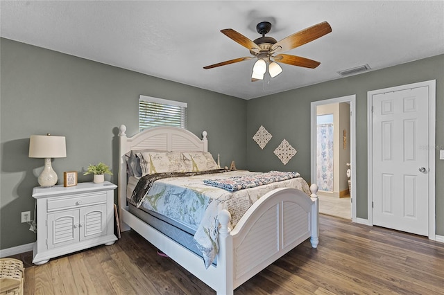 bedroom featuring visible vents, baseboards, and wood finished floors