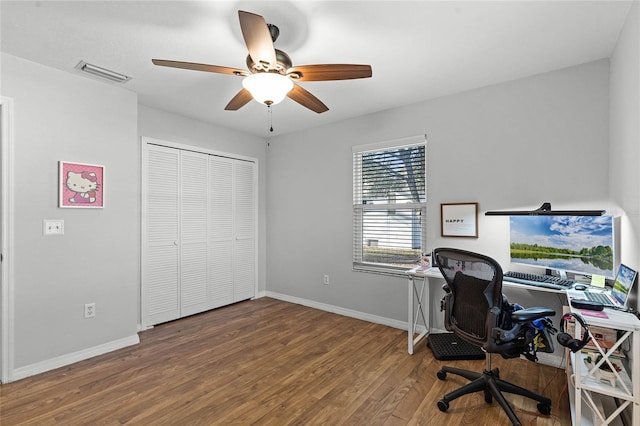 office space with a ceiling fan, wood finished floors, visible vents, and baseboards