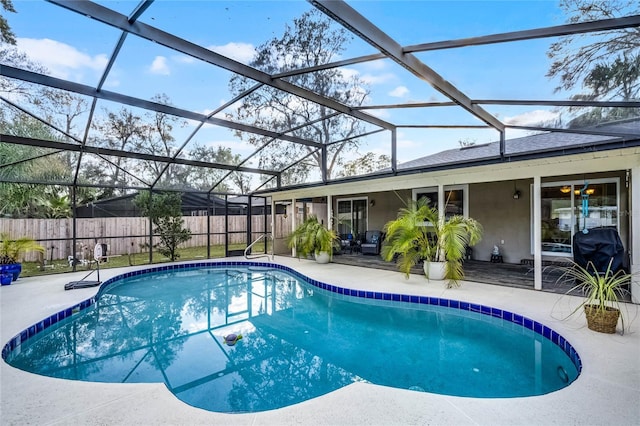 view of swimming pool featuring a lanai, fence, a grill, a fenced in pool, and a patio area