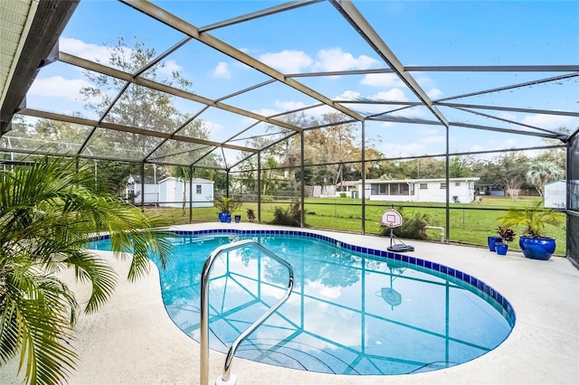 outdoor pool with a patio, a lanai, an outdoor structure, a lawn, and a storage unit