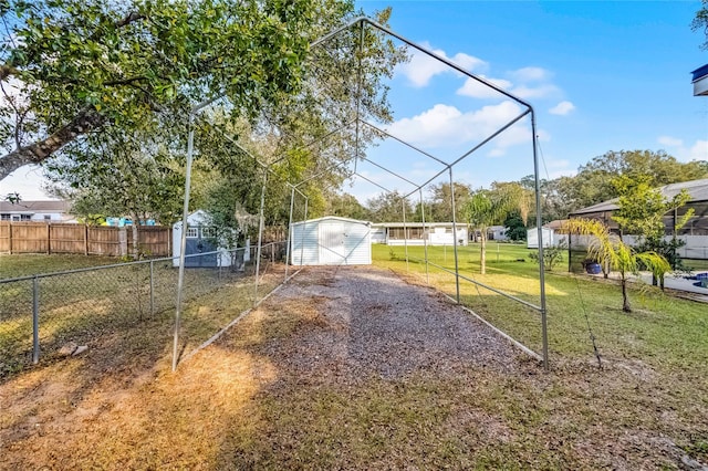 view of yard with an outdoor structure, fence, and a shed