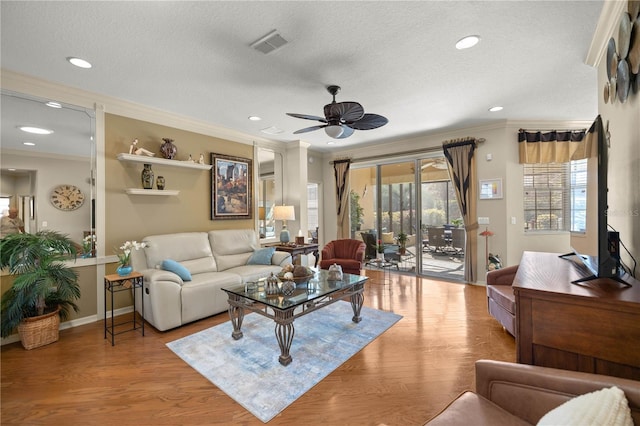 living area with ornamental molding, a wealth of natural light, and wood finished floors