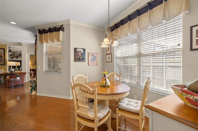 dining room with baseboards, crown molding, and wood finished floors