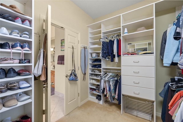 spacious closet featuring light tile patterned floors and light carpet