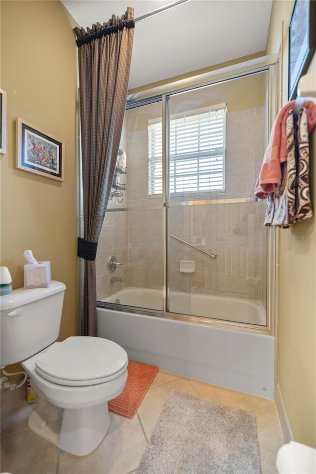 bathroom with toilet, shower / bath combination with glass door, and tile patterned flooring