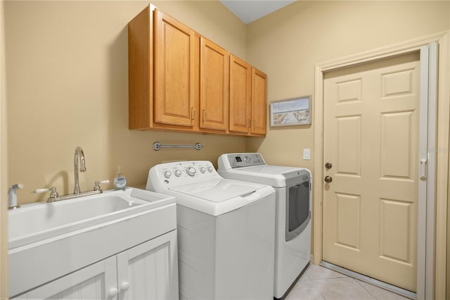 clothes washing area featuring light tile patterned floors, independent washer and dryer, a sink, and cabinet space