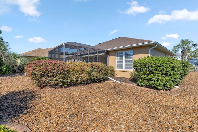 back of property with a lanai and stucco siding