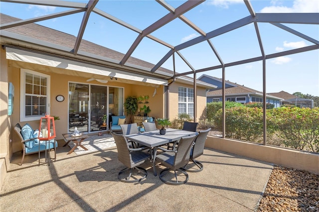 exterior space featuring glass enclosure, outdoor dining space, and a ceiling fan