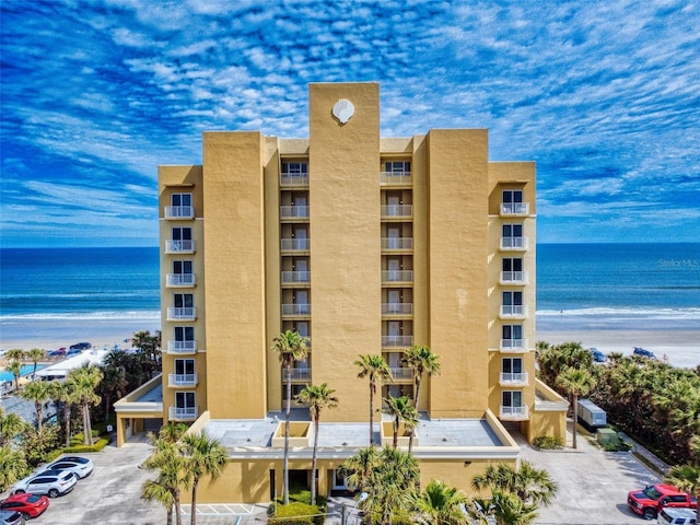 view of building exterior featuring uncovered parking and a water view