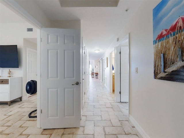 hallway featuring visible vents and baseboards