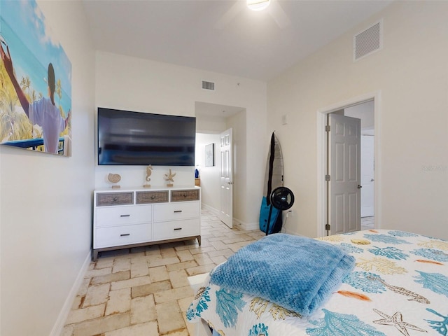 bedroom with baseboards, visible vents, and stone tile floors