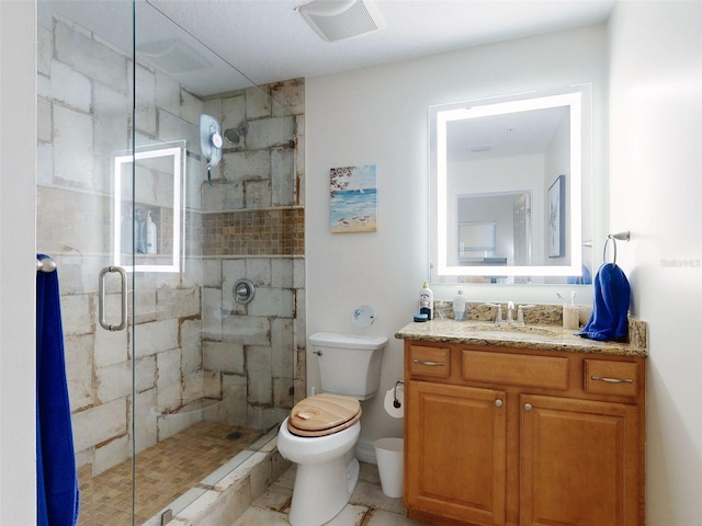 bathroom featuring visible vents, a stall shower, vanity, and toilet