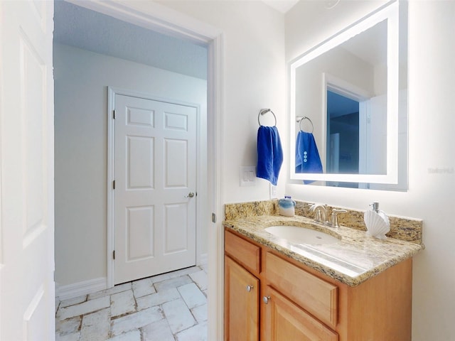 bathroom featuring marble finish floor, baseboards, and vanity