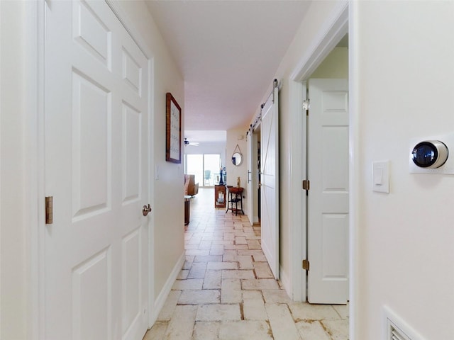 corridor featuring a barn door