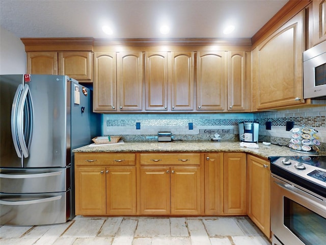 kitchen featuring appliances with stainless steel finishes, decorative backsplash, and light stone countertops