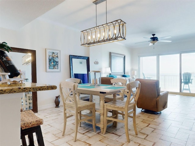 dining area with ceiling fan with notable chandelier, ornamental molding, and baseboards