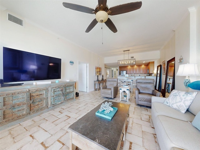 living area with ornamental molding, visible vents, and ceiling fan