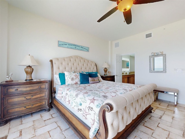 bedroom featuring a ceiling fan, visible vents, ensuite bath, and stone tile floors