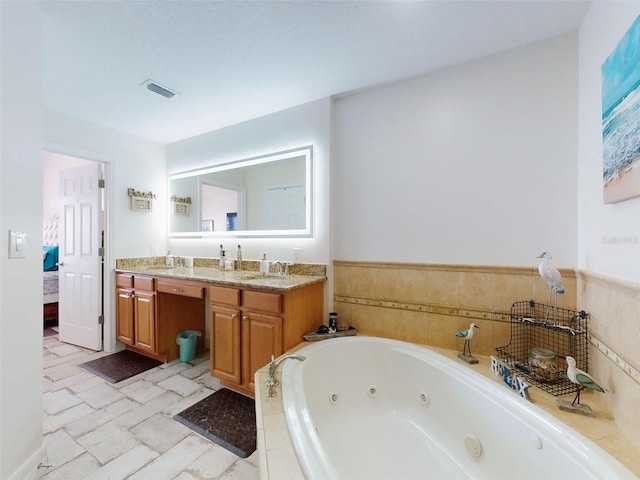 bathroom with a whirlpool tub, double vanity, a sink, and visible vents