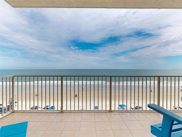 balcony featuring a water view and a beach view