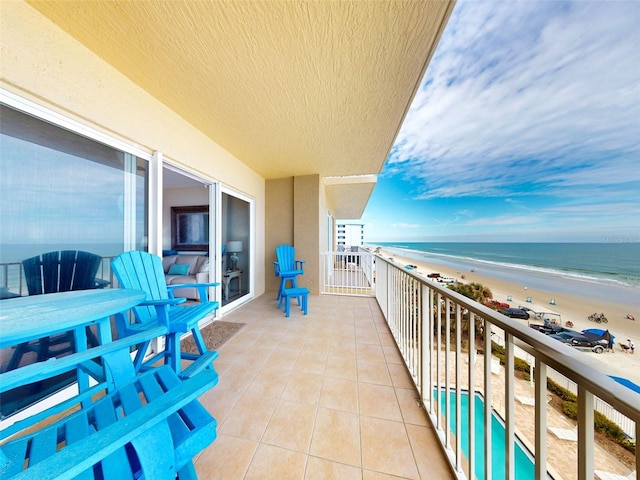 balcony with a water view and a beach view