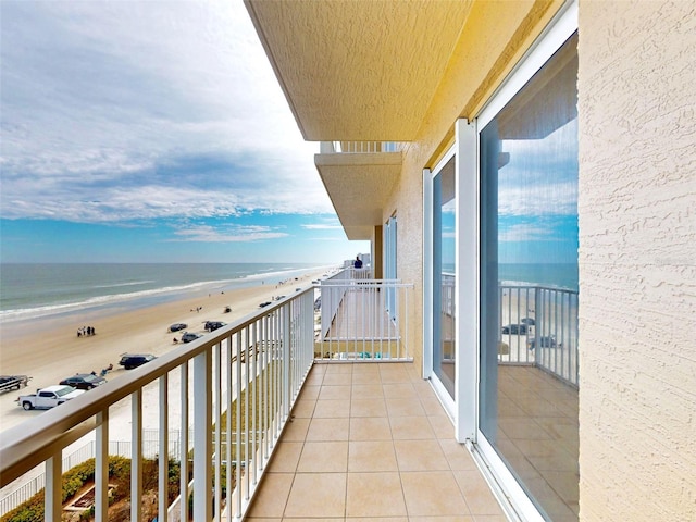 balcony with a water view and a view of the beach