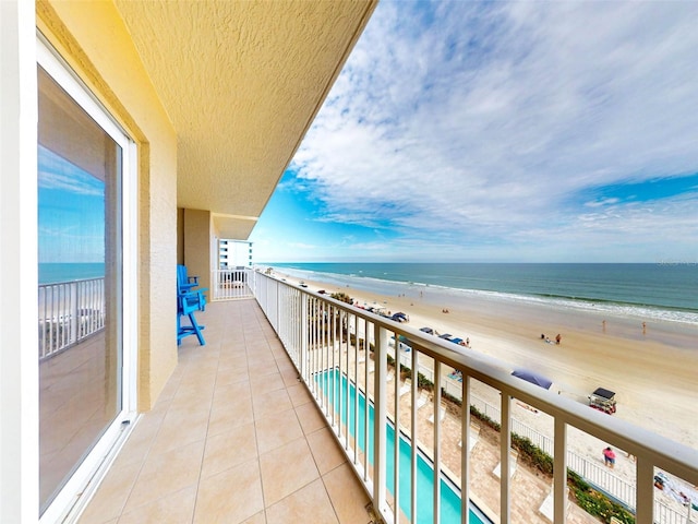 balcony featuring a water view and a view of the beach