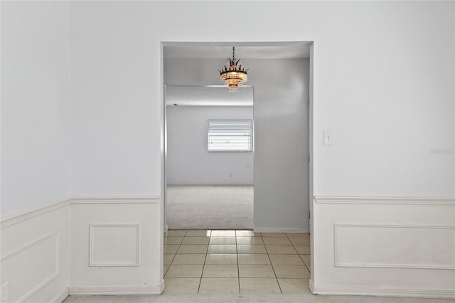 carpeted spare room with a decorative wall and tile patterned floors