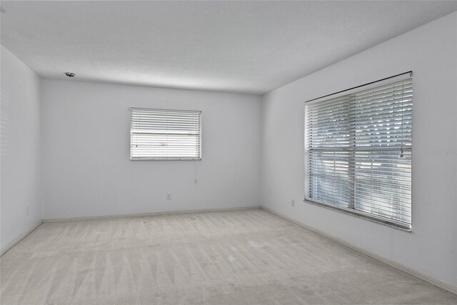 empty room with a textured ceiling and carpet