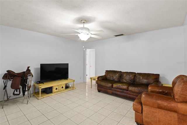 living room featuring ceiling fan, visible vents, a textured ceiling, and light tile patterned flooring